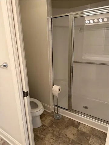 a bathroom with a toilet and a shower