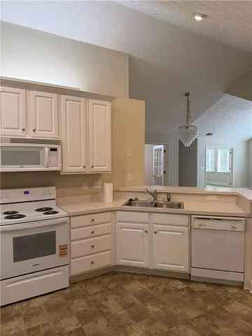 a kitchen with white cabinets and white appliances