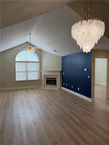 an empty room with wooden floor and chandelier