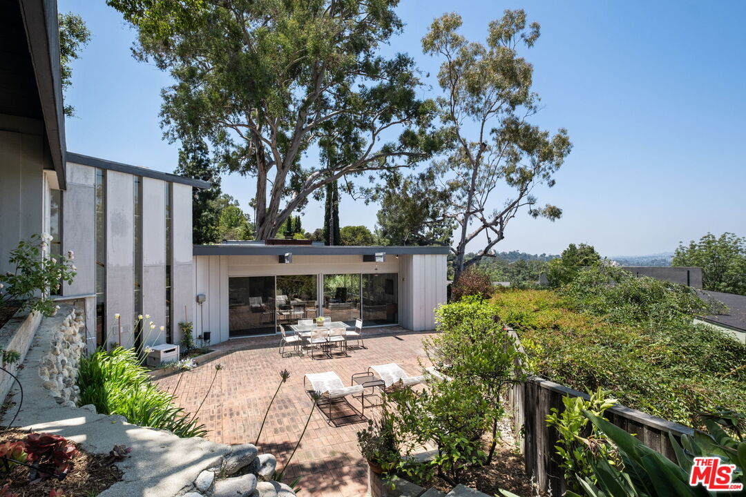 316 Redwood Drive Pasadena, CA 91105 - Photo 37 of 49 a view of a patio with table and chairs potted plants and large tree