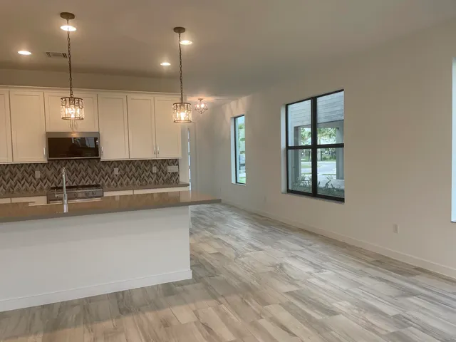a view of a kitchen island a chandelier and wooden floor