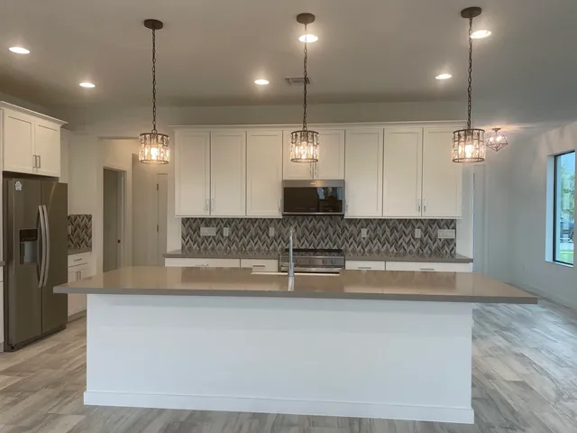 a large kitchen with kitchen island a large island in it