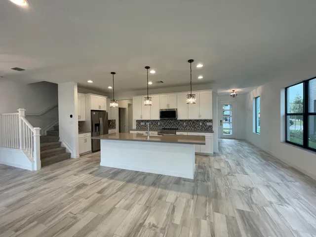 an empty room with windows and ceiling fan