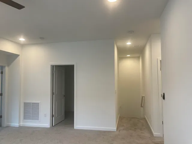 an empty room with a ceiling fan and window