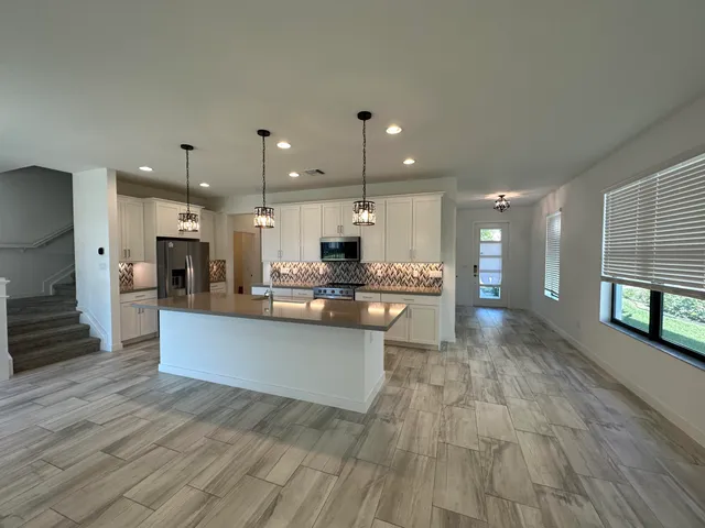 a view of a hallway with a refrigerator and dining table