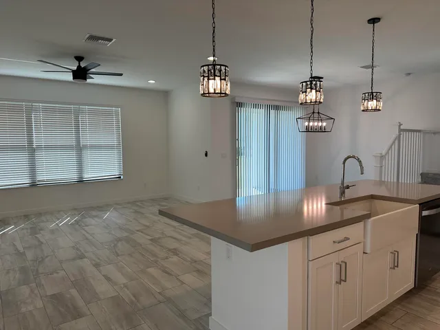 a large kitchen with stainless steel appliances kitchen island a large counter top and a wooden floors