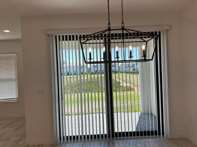 an empty room with a ceiling fan and windows