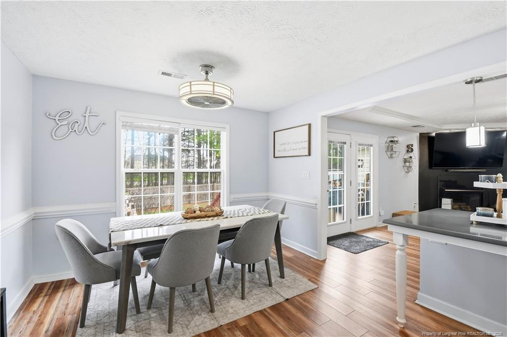 212 Lennox Loop Raeford, NC 28376 - Photo 16 of 47 a view of a dining room with furniture a chandelier and wooden floor