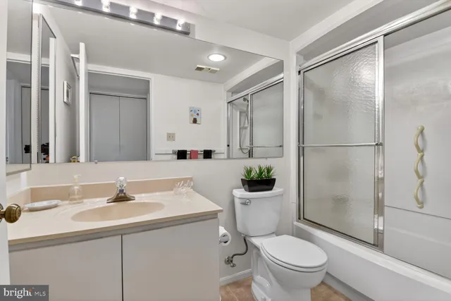 a large bedroom with a bed and wooden floor