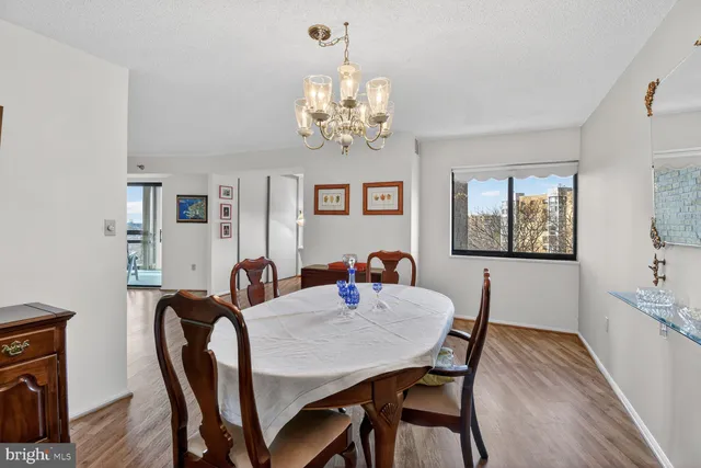 a view of a dining room with furniture a chandelier and wooden floor