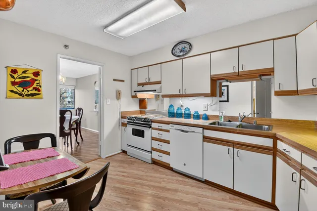a kitchen with stainless steel appliances a stove a sink cabinets and wooden floor