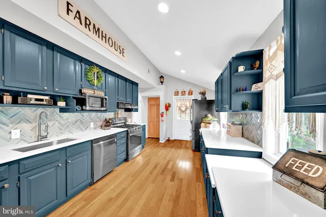 a large kitchen with stainless steel appliances granite countertop a large stove a sink dishwasher and cabinets with wooden floor