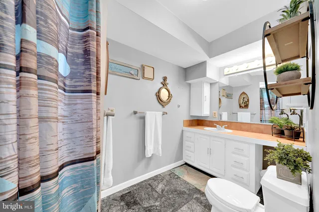 a bathroom with a granite countertop sink mirror vanity and toilet