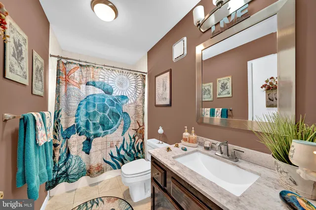 a bathroom with a granite countertop sink a mirror and a toilet