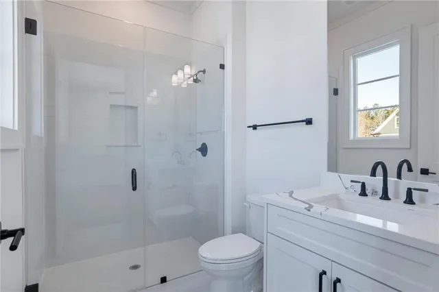 a spacious bathroom with a double vanity sink a mirror and a shower