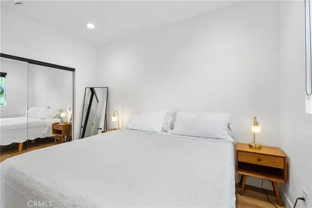 a bedroom with a bed and wooden floor