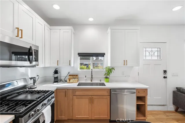 a kitchen with stainless steel appliances a sink stove and cabinets