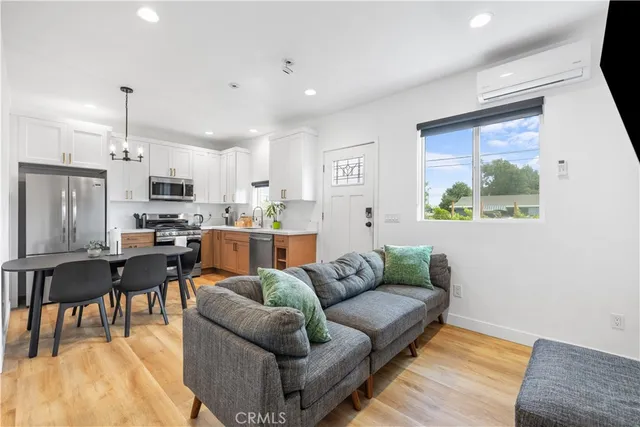 a living room with stainless steel appliances furniture and a open kitchen view