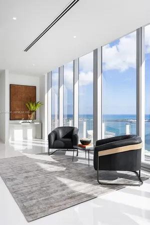 a living room with a large window and a glass door