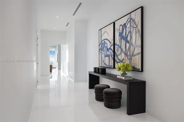 a hallway with a table and a painting on the wall
