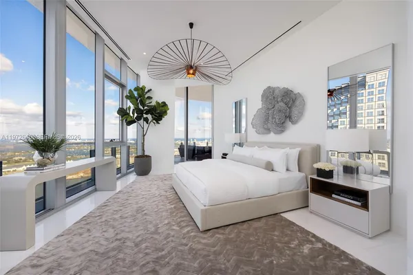 a bedroom with a large bed and a chandelier