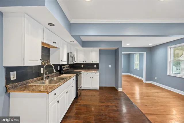 a kitchen with granite countertop a sink dishwasher stove and cabinets