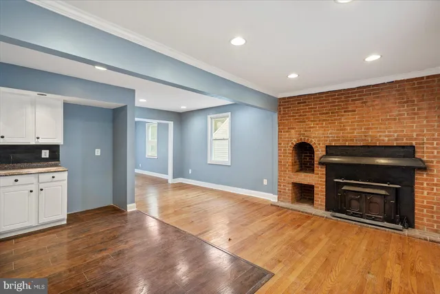 a view of empty room with wooden floor and fireplace