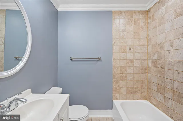 a white toilet sitting next to a bathroom sink and vanity