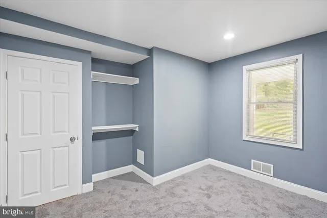 an empty room with windows and closet