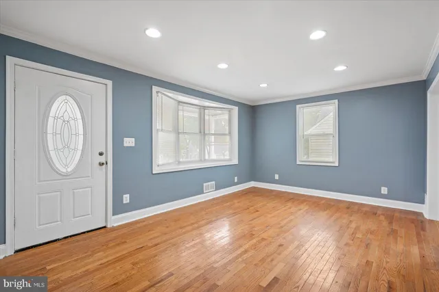 wooden floor in an empty room with a window