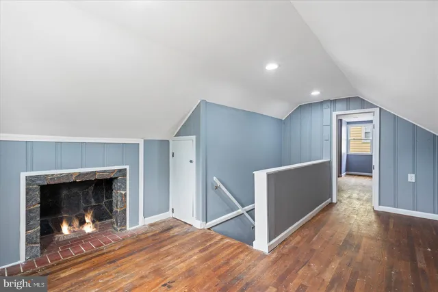 a view of a livingroom with wooden floor and a fireplace