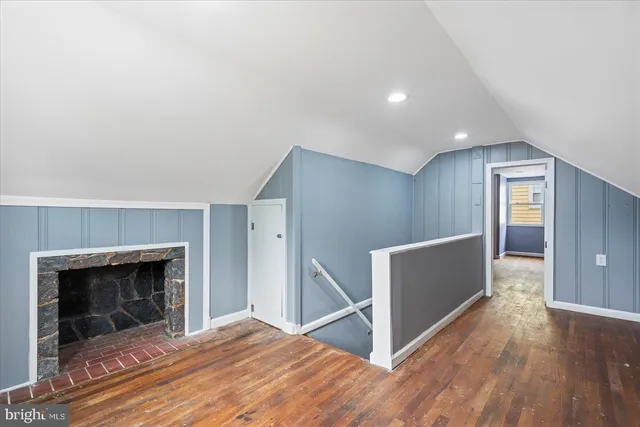 a view of empty room with wooden floor and fireplace