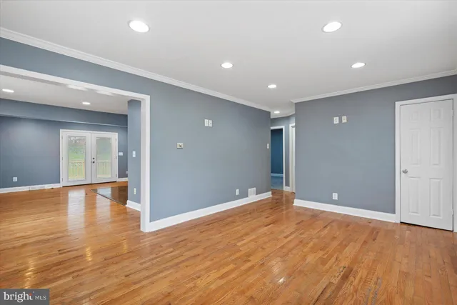 a view of an empty room with wooden floor