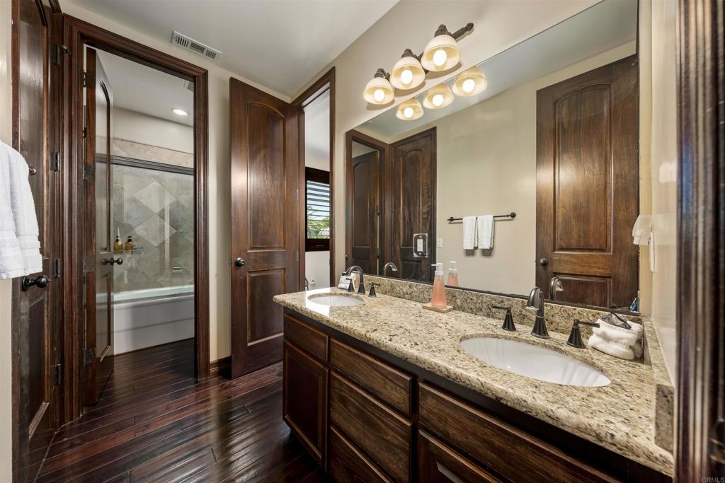 5765 Soledad Mountain Road La Jolla, CA 92037 - Photo 12 of 22 a bathroom with a granite countertop sink a mirror and shower