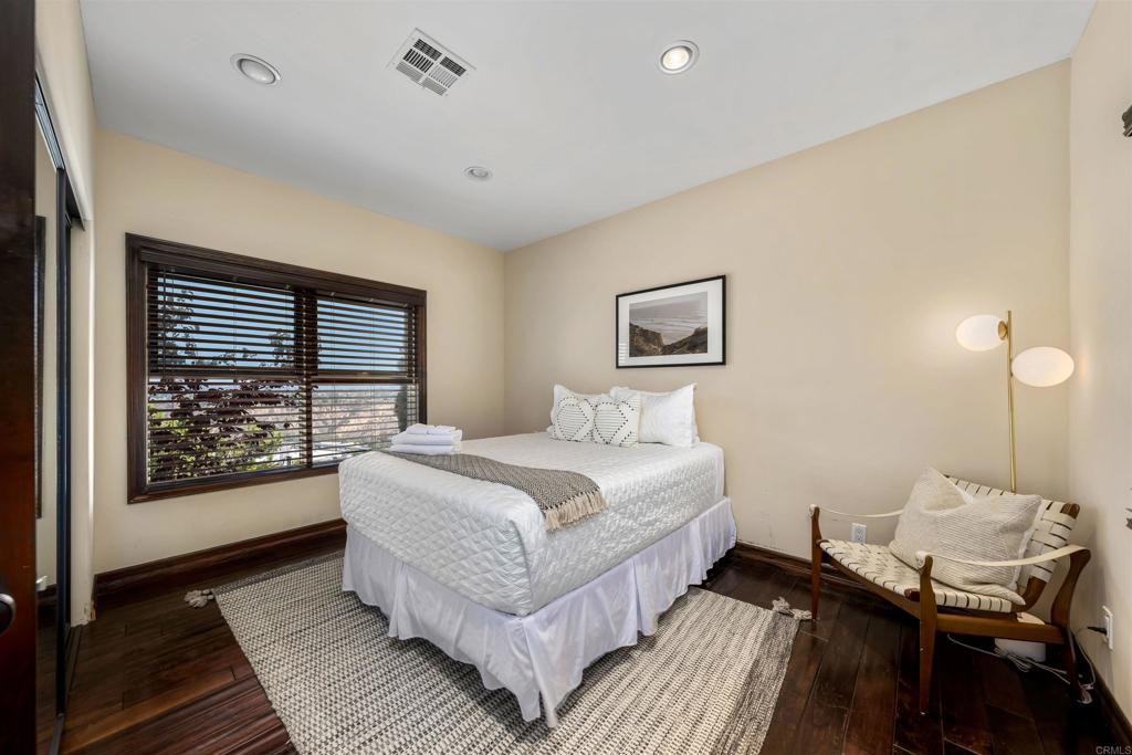 5765 Soledad Mountain Road La Jolla, CA 92037 - Photo 13 of 22 a bedroom with a bed and wooden floor