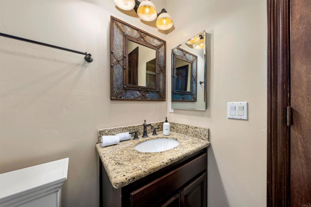 5765 Soledad Mountain Road La Jolla, CA 92037 - Photo 15 of 22 a bathroom with a granite countertop sink and a mirror