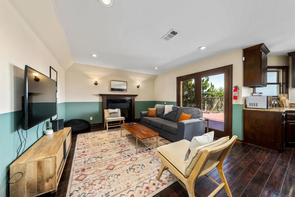5765 Soledad Mountain Road La Jolla, CA 92037 - Photo 6 of 22 a living room with furniture a flat screen tv and a fireplace