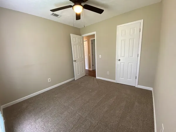 an empty room with chandelier fan