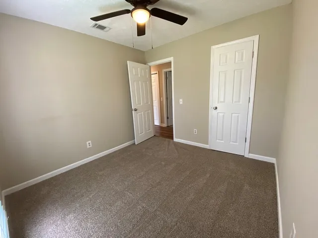 an empty room with chandelier fan