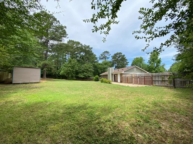a view of a big yard with large trees and plants