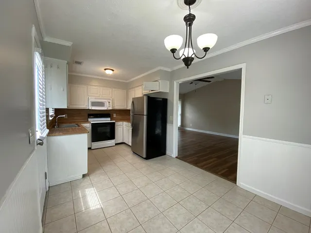 a kitchen with a refrigerator a stove top oven and cabinets