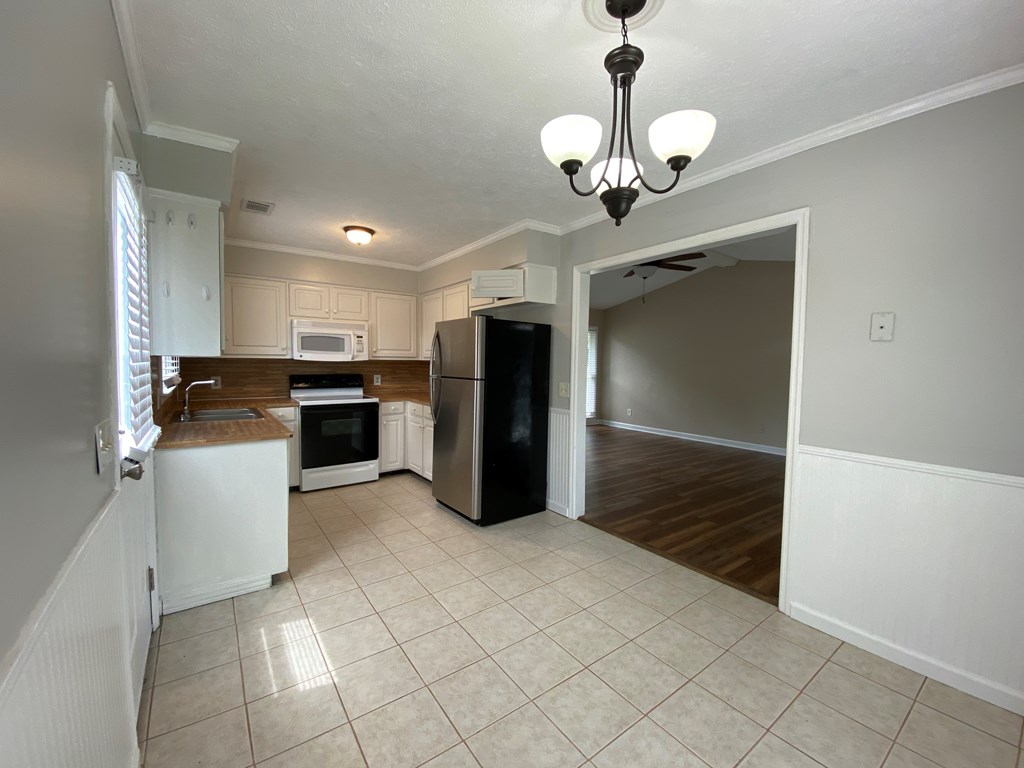 3 Deland Court Columbus, GA 31904 - Photo 5 of 27 a kitchen with a refrigerator a stove top oven and cabinets