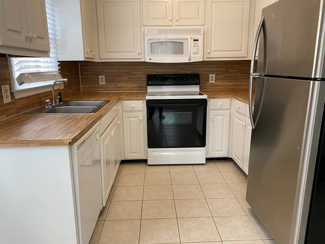 a kitchen with a refrigerator sink and cabinets