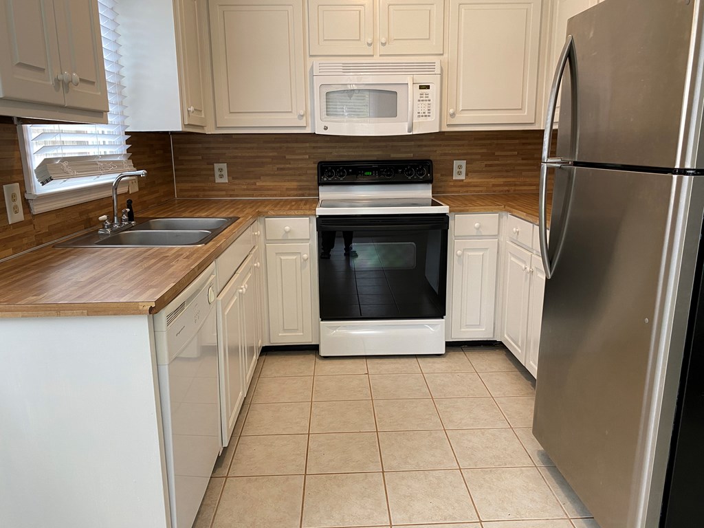 3 Deland Court Columbus, GA 31904 - Photo 6 of 27 a kitchen with a refrigerator sink and cabinets