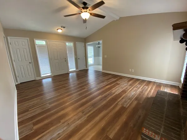 wooden floor in an empty room with a window