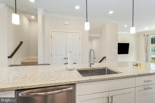 a kitchen with a sink a faucet a counter and chairs