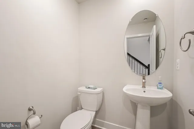 a bathroom with a toilet sink and mirror