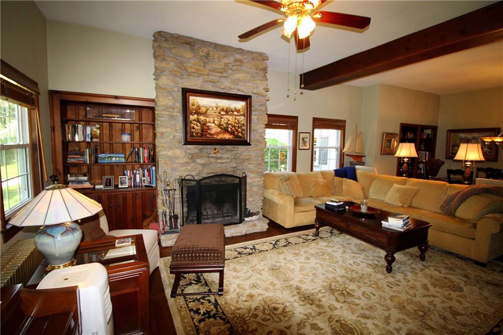 163 Sugar Run Road Eighty Four, PA 15330 - Photo 5 of 25 Living room with log burning fireplace and built-in knotty pine book case.
