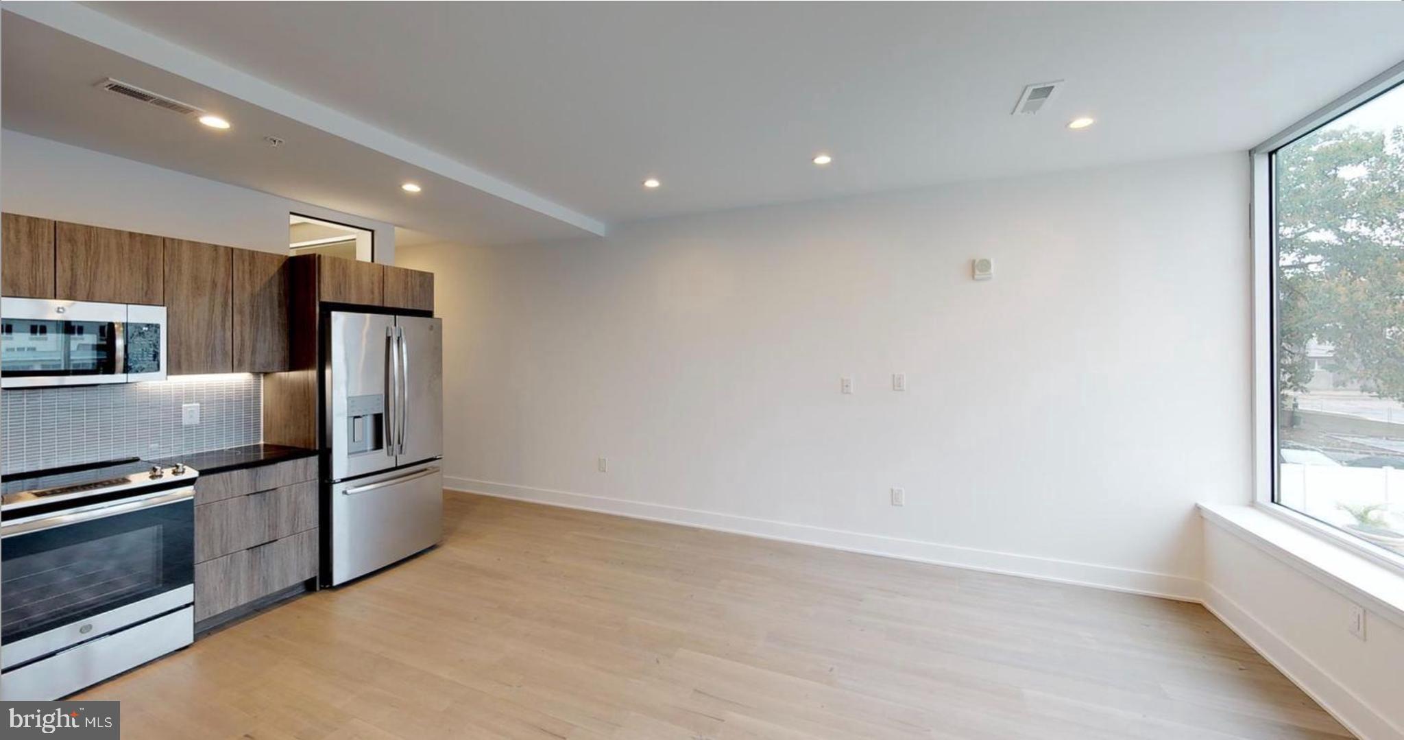 1 Brown Street, Unit STUDIO Philadelphia, PA 19123 - Photo 3 of 14 a view of a kitchen with stainless steel appliances a refrigerator and a window