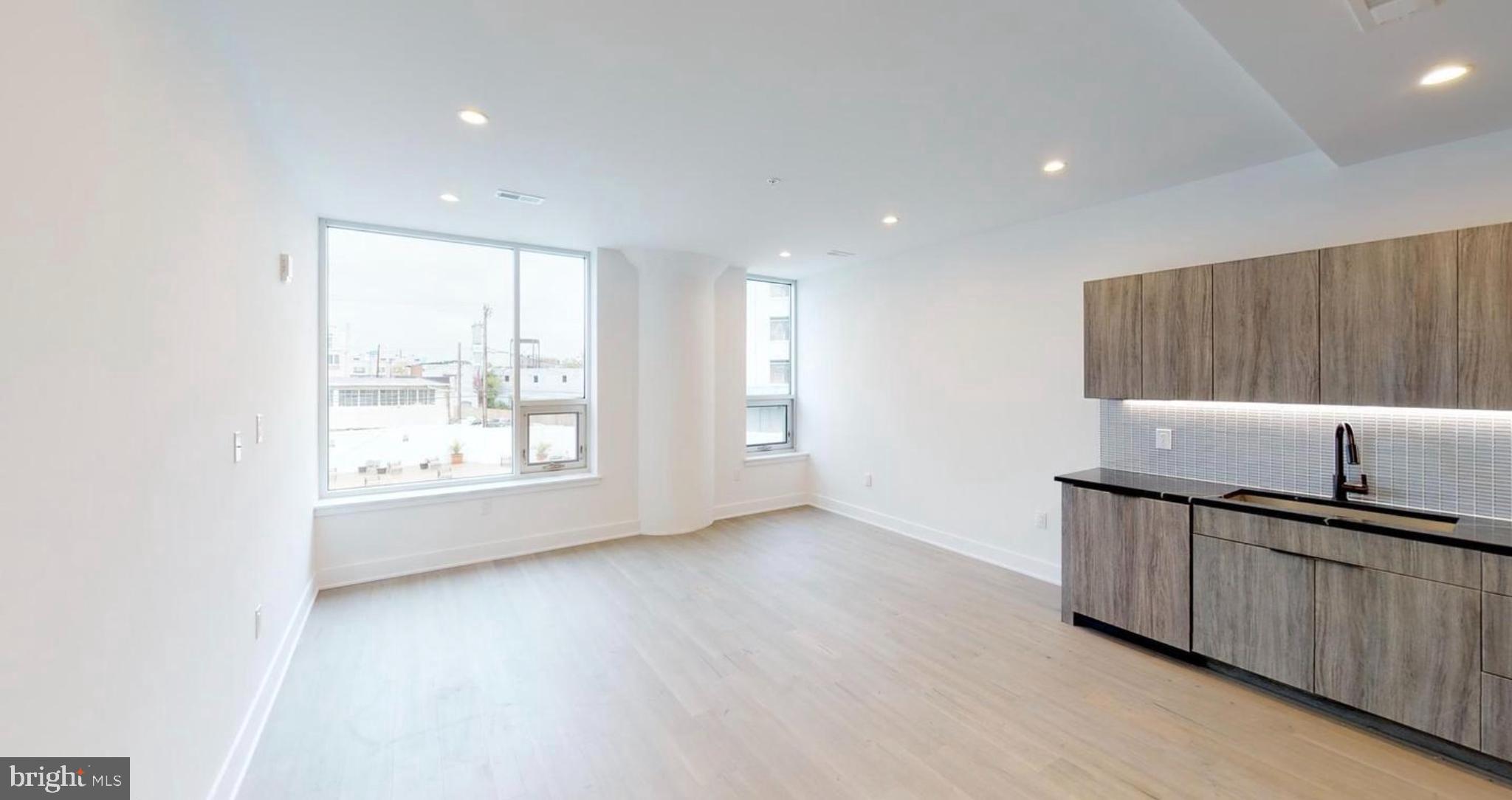 1 Brown Street, Unit STUDIO Philadelphia, PA 19123 - Photo 4 of 14 an empty room with wooden floor and windows